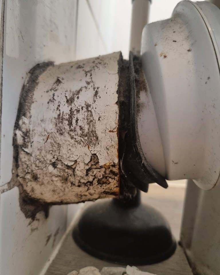 Corroded, damaged waste pipe connection before repair